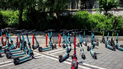 A row of electric scooters lined up in an outdoor parking lot in Istanbul, Turkey.